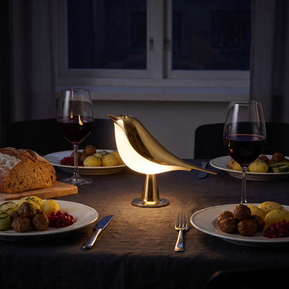 Lumélia dorée, seule source de lumière sur une table dressée pour deux