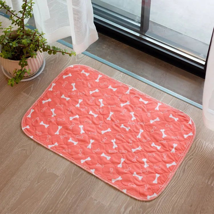 Tapis de propreté lavable Pattéa corail à motif os posé au sol devant une porte-fenêtre